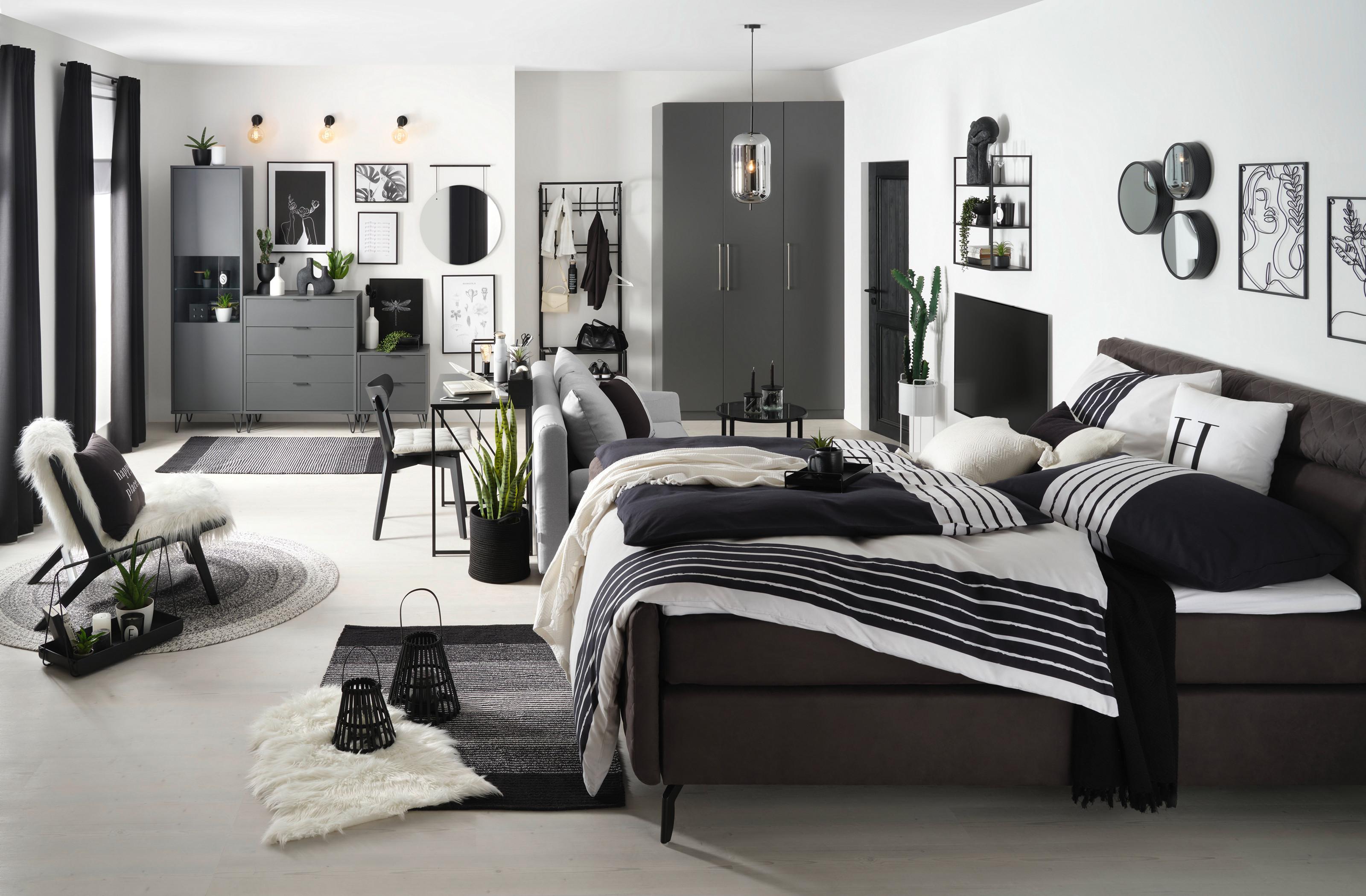 ložnice zařízená v kontrastní bílé a černé barvě