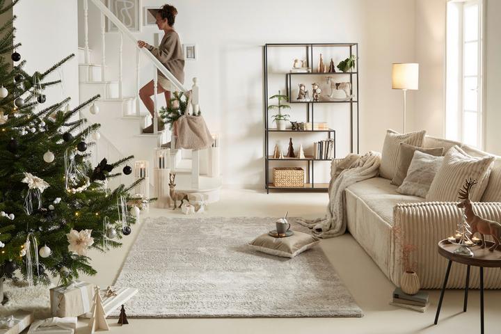 Weihnachtlich geschmücktes Wohnzimmer mit Treppenaufgang.