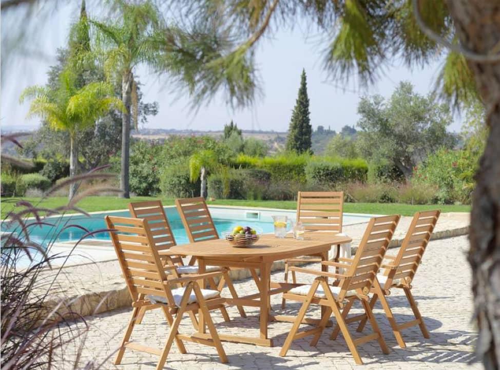 Sitzgruppe aus Holz neben Pool im Garten