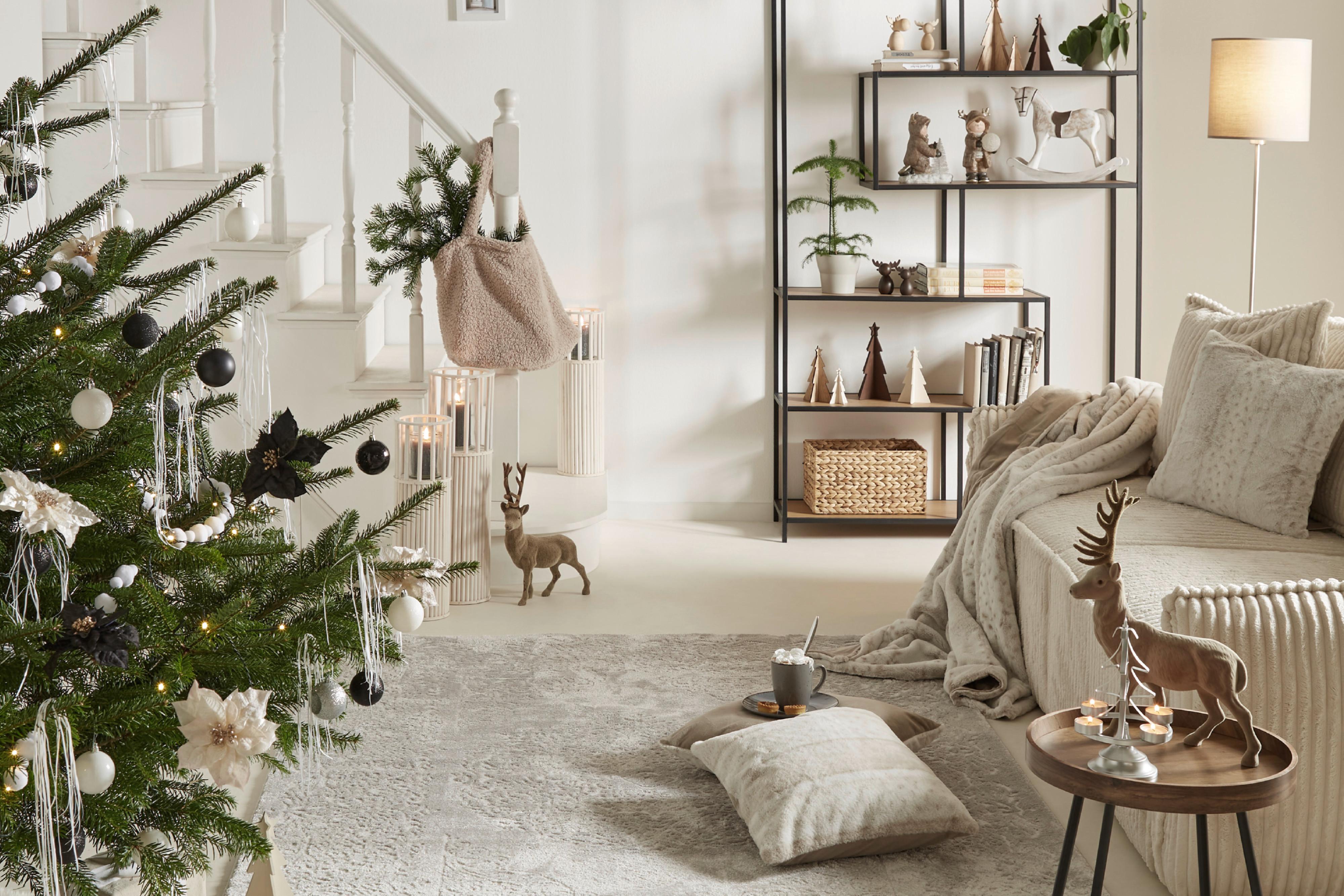 Ein Wohnzimmer mit Treppenaufgang weihnachtlich dekoriert.