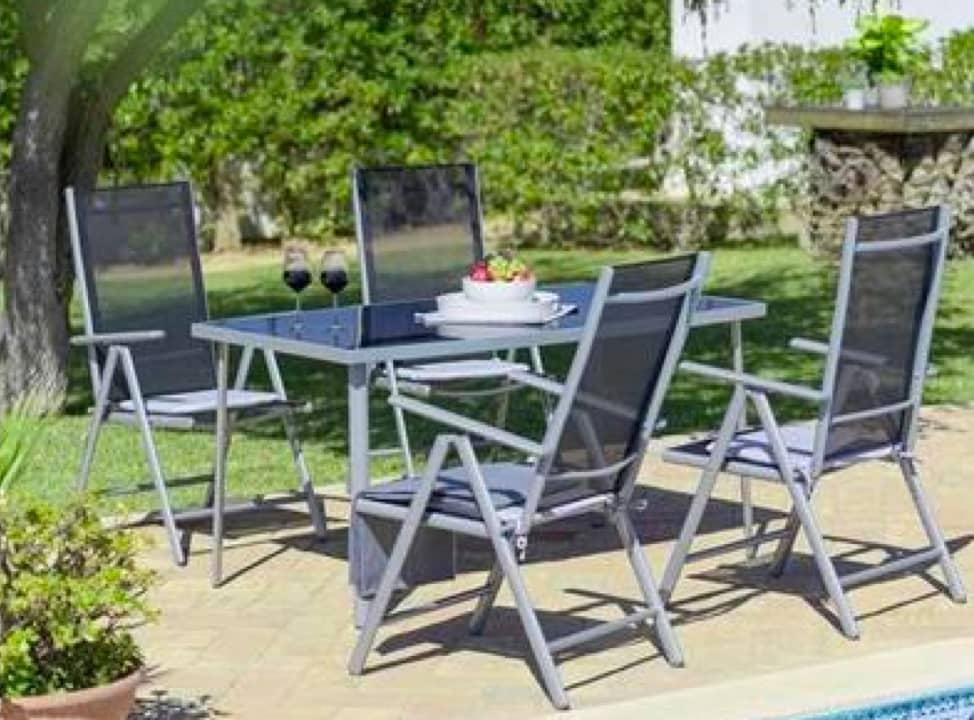 Sitzgruppe aus Metall neben Pool im Garten