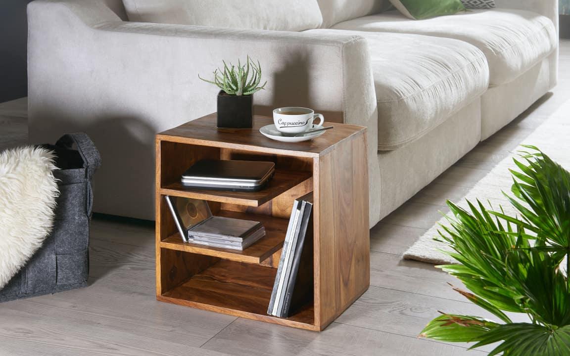 Pflanze und Tasse auf Holzregal vor Sofa