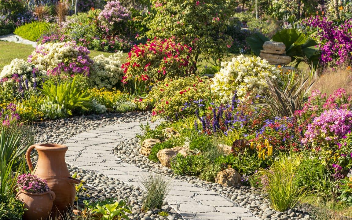 Geschwungener Weg durch Blumenbeet