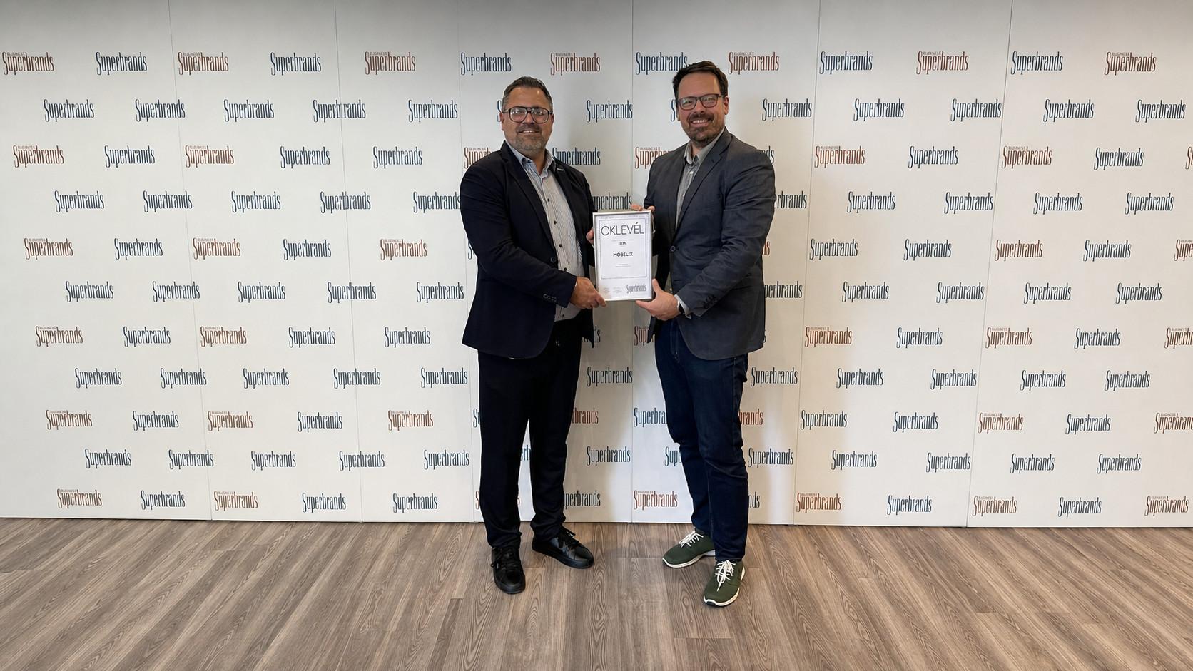 A képen Flach Nándor cégvezető, értékesítési vezető veszi át a Superbrands díjat.