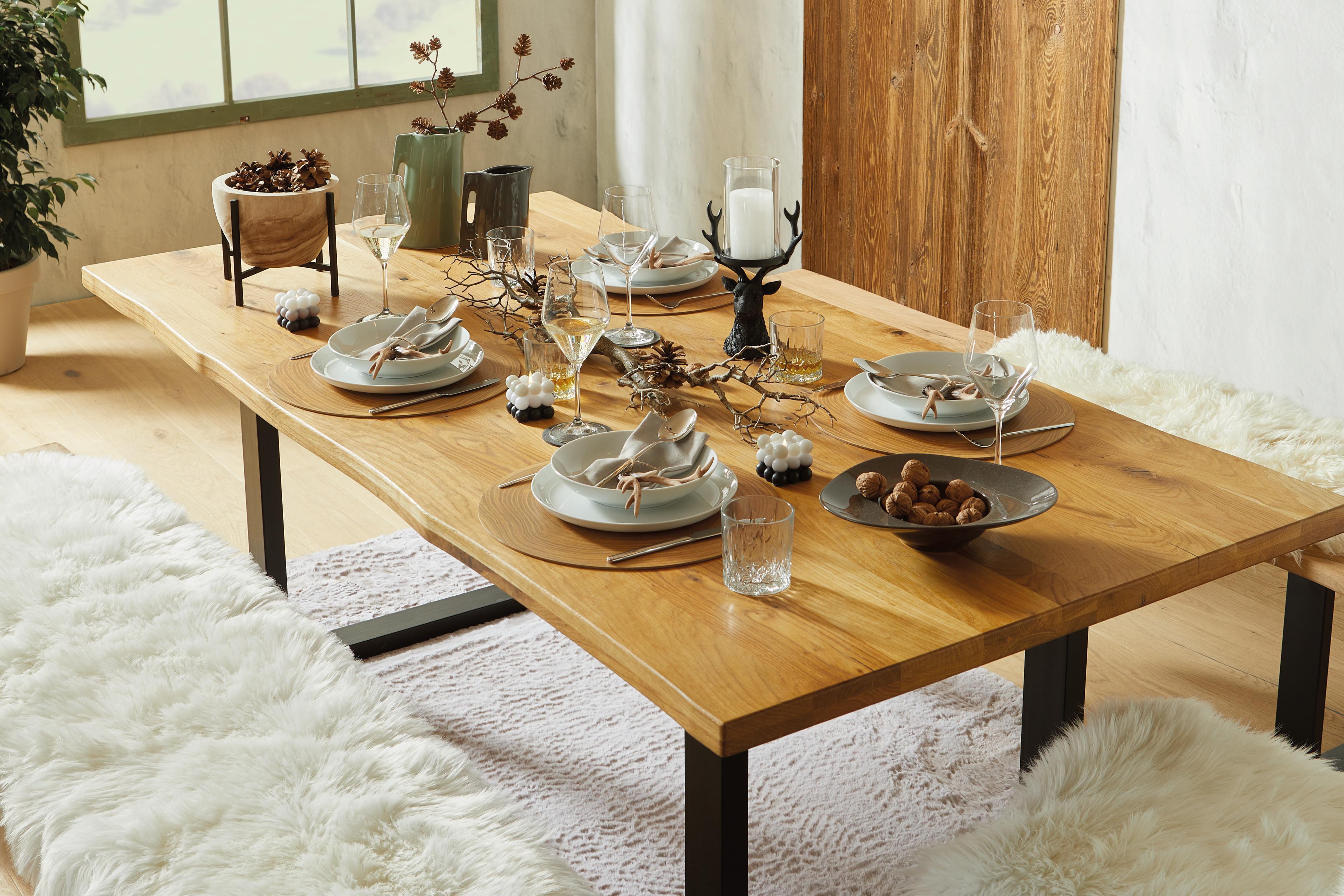 Ein gedeckter Holztisch mit natürlichen Accessoires und klassischem Geschirr.