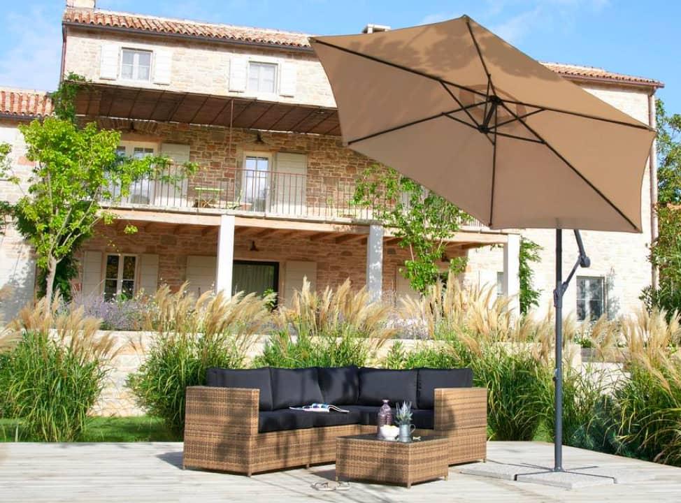 Sonnenschirm über Sitzgruppe im Garten