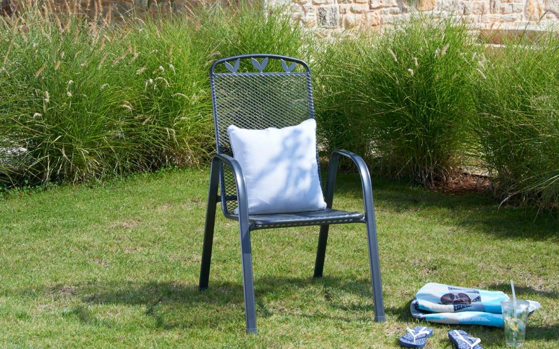 Blauer Gartensessel auf grüner Wiese