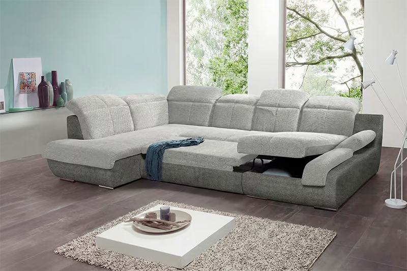 Tágas, modern nappali szürke sarokülőgarnitúrával állítható relax funkcióval, minimalista dohányzóasztallal és világos, nagy ablakos háttérrel.