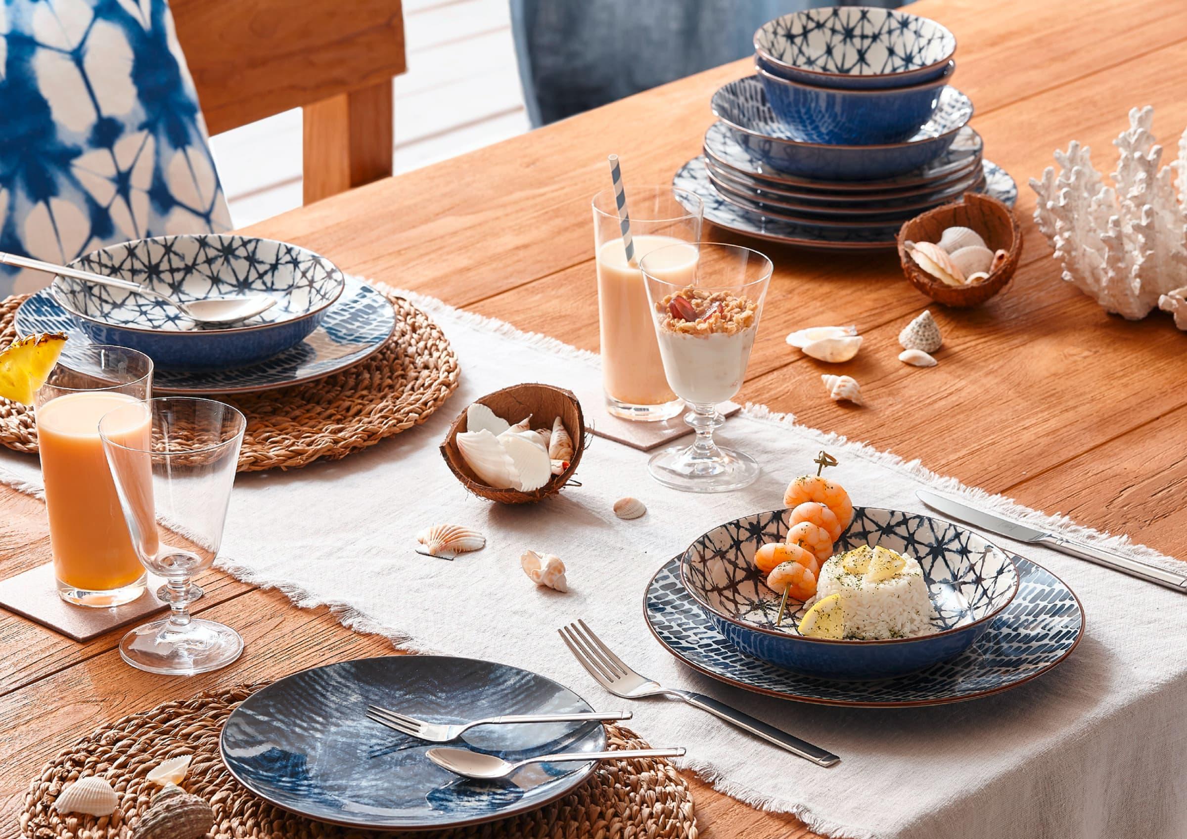 Geschirr, Getränke und Dekoration auf Tisch