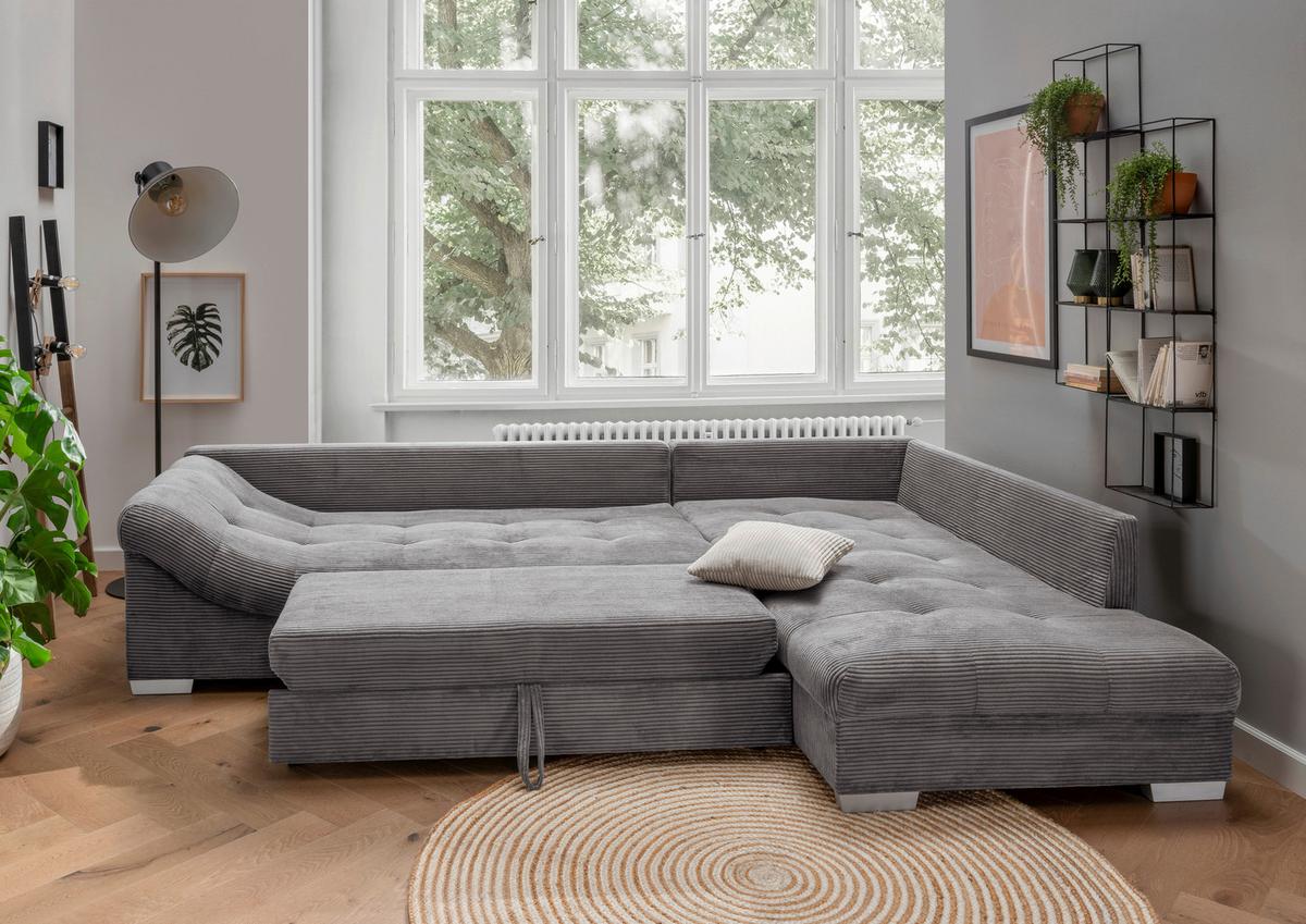 Graues Ecksofa mit Schlaffunktion sowie Rücken- und Zierkissen