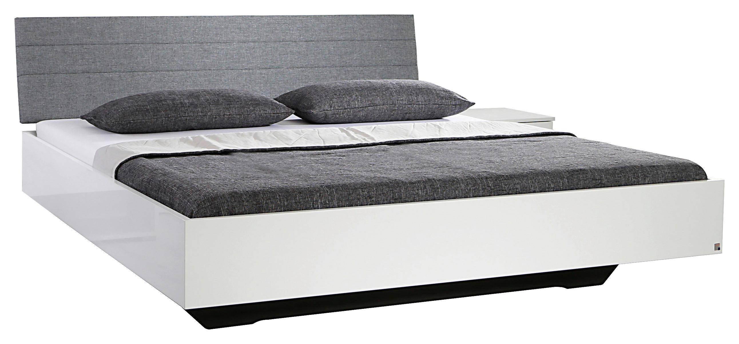 Weißes Bett mit gepolstertem Kopfteil in Grau